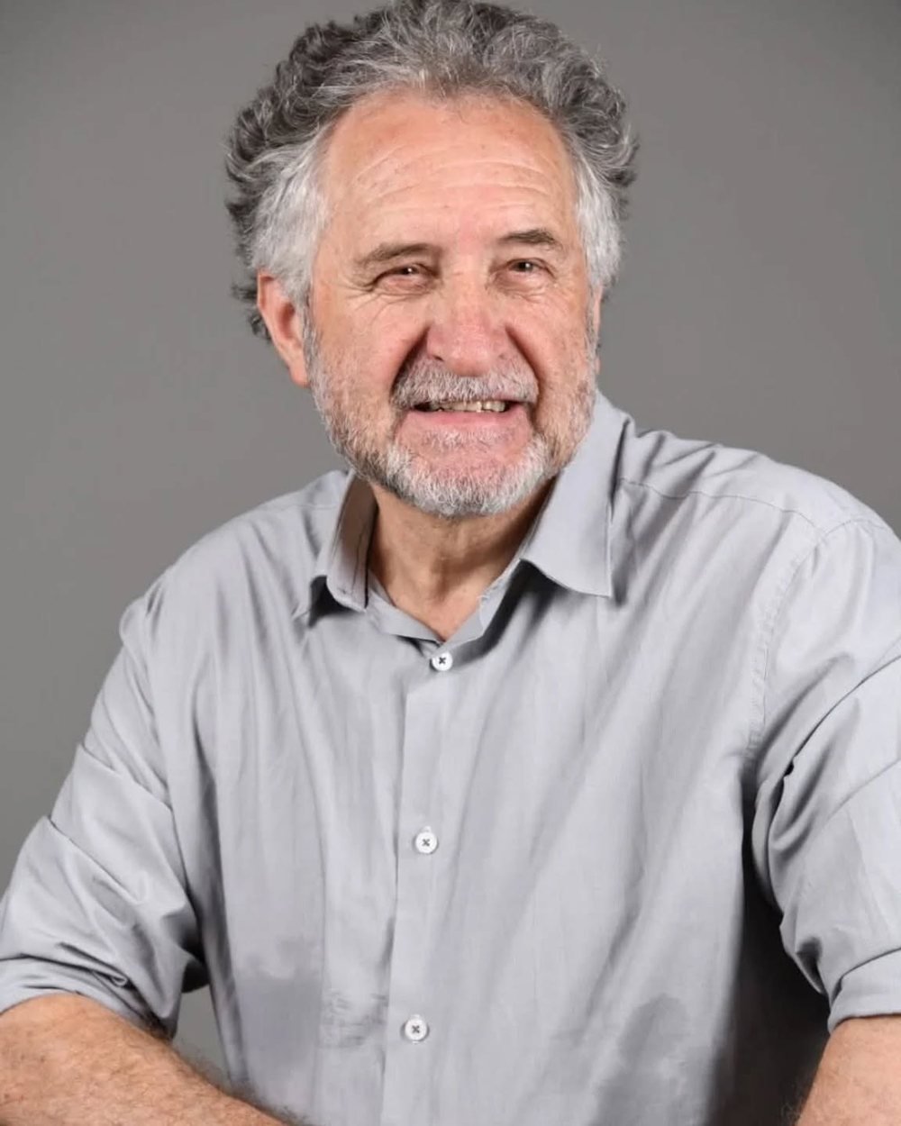 Retrato de Paulo Cardoso, sorrindo, de camisa cinza